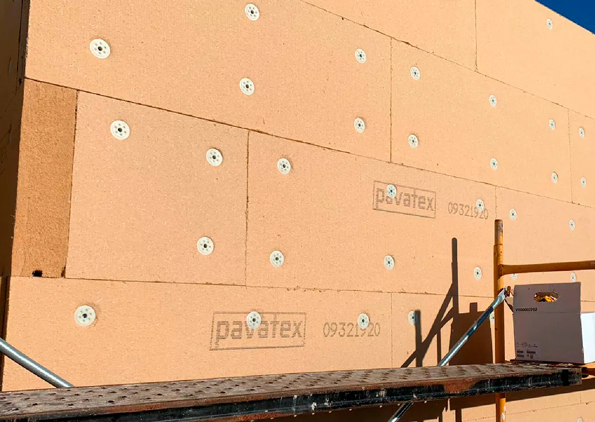 Paneles aislantes de fibra de madera Pavatex de Soprema fijados en la fachada de un edificio en obra